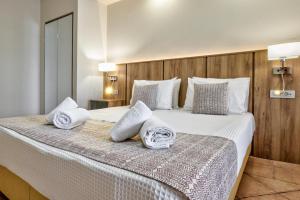拉加纳斯White Olive Premium Laganas的一间卧室配有一张大床和毛巾