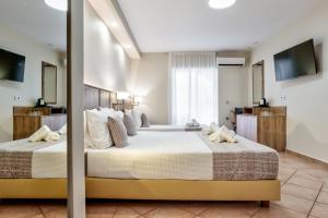 拉加纳斯White Olive Premium Laganas的一间大卧室,配有两张床和电视