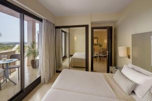 厄尔-汝姆披多朗皮多俱乐部精品度假酒店的酒店客房设有一张床和一个阳台。