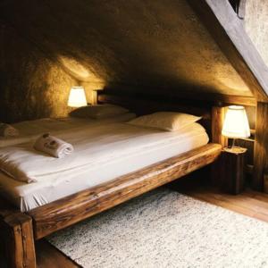 埃格尔Excalibur miniHotel的一张木床,在房间内配有两盏灯