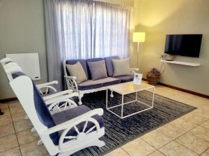阿多Summerville Place的客厅配有沙发、椅子和桌子