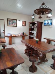 大坎普Pousada Estância Mineira的用餐室配有木桌和长椅