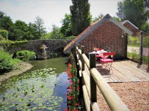 DangeauLe Lavoir Secret - hébergement atypique dans un joli cadre bucolique的池塘旁甲板上的桌子