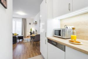 布达佩斯Marina apartment at Danube - FREE PRIVATE PARKING!的白色的厨房配有微波炉和桌子