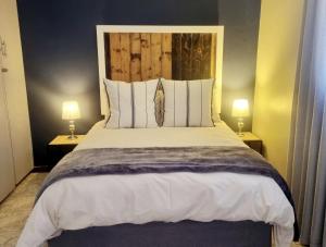 阿多Summerville Place的一间卧室配有一张大床和两盏灯