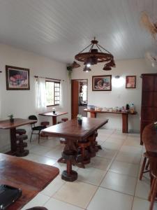 大坎普Pousada Estância Mineira的一间带木桌和椅子的用餐室