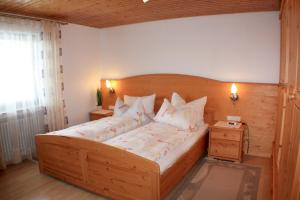 埃尔察赫Schlosshof - der Urlaubsbauernhof的卧室配有带白色枕头的大型木质床。