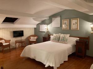 佩琼帕萨达梅尔朗特酒店的卧室配有白色的床和电视