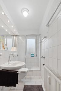 汉诺威Stadt-Apartment 3 Zimmer mit Terasse的白色的浴室设有水槽和淋浴。