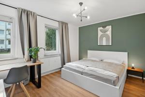 汉诺威Stadt-Apartment 3 Zimmer mit Terasse的卧室配有一张床、一张书桌和窗户。