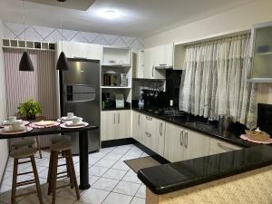 弗洛里亚诺波利斯Casa em Florianopolis Praia do Moçambique的厨房配有桌子和冰箱