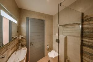 Álika阿里卡度假酒店的带淋浴、卫生间和盥洗盆的浴室