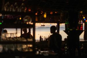 俊穆岛JOY简易别墅度假村&餐厅的坐在海洋前酒吧里的人