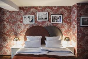 柏林马戏团酒店的卧室配有一张大床,墙上挂有三幅画
