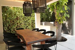 卢汉德库约Heura Petit Hotel的一张带黑色椅子的木桌和植物
