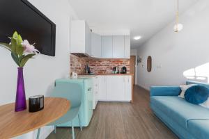 华沙RentPlanet - Apartamenty Wiktoryn的客厅配有蓝色的沙发和桌子