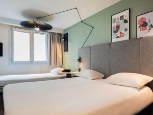 巴黎巴黎托尔比亚克宜必思酒店的酒店客房,设有两张床和镜子
