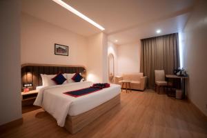 甘托克Zip By Spree Hotels Gangtok的酒店客房设有一张大床和一张书桌。