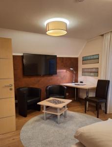 希尔波尔特施泰因祖尔克朗潘森伽尼酒店的客厅配有桌椅和电视。
