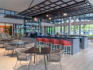雪邦ibis Styles Sepang KLIA的一间带桌椅的餐厅和一间酒吧