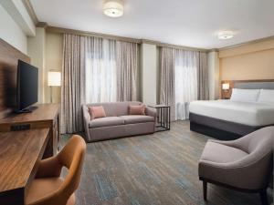 新奥尔良Hampton Inn & Suites New Orleans Canal St. French Quarter的酒店客房配有床、沙发和电视。