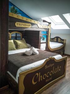 平托El Indio CHocolatería Boutique Hostel的一间卧室设有两张双层床,还有一块巧克力标志