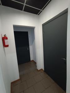 波尔塔瓦Atlas Hotel的走廊设有黑色门,铺有瓷砖地板