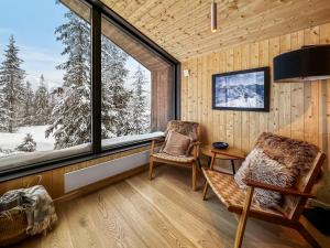 StrandeSki-in-out hytte på Kvitfjell的客房设有窗户、两把椅子和一张桌子