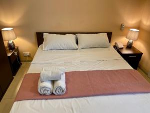 圣朱利安斯Malta Paradise Central Accomodation的一间卧室配有带毛巾的床