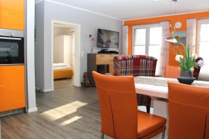 蒂索Haus Sonne的一间拥有橙色墙壁和桌椅的用餐室