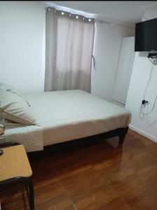 卡尔德拉Hospedaje GYT Caldera的一间小卧室,配有一张带窗户的床