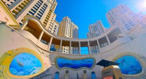 迪拜The W Jumeirah Beach的一座建筑,拥有大型水族馆和高大的建筑