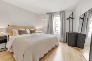 奥斯陆Flott leilighet i hjerte av Oslo的白色卧室设有一张大床和两个窗户