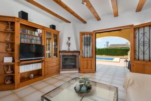 卡尔佩Villa Escudero - Plusholidays的一间带电视和壁炉的客厅