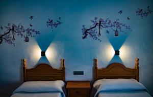 巴萨HOSTAL CACHE的卧室设有两张床,拥有蓝色的墙壁和两个灯