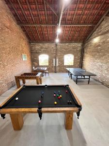 奥兰布拉Rancho da Cachaça Pousada的一个带两张乒乓球桌的房间的一张台球桌