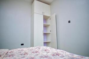 KiraATA Lux Apartments的一间卧室配有床和白色橱柜