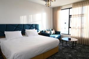 奈季兰SUN SET HOTEL فندق سن ست的酒店客房设有一张大床和一张沙发。