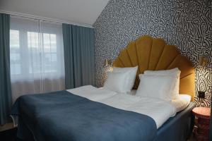 厄勒布鲁厄勒布鲁克拉丽奥酒店的一间卧室配有一张带蓝色棉被的大床