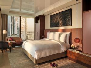 迪拜The Lana - Dorchester Collection的酒店客房设有一张大床和一张书桌。