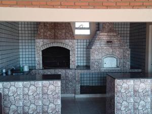 博图卡图casa c/4 dormitórios e piscina的一间厨房,内设石炉