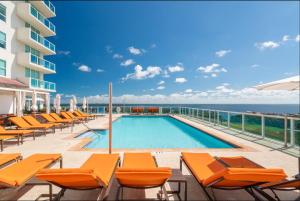 迈阿密Balcony Ocean View ! Pool - WiFi - Gym - Parking的一个带橙色椅子的游泳池以及大海