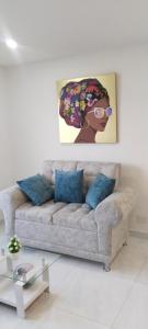 内瓦Hermoso Apartamento en Neiva的客厅配有一张沙发,墙上挂有绘画作品