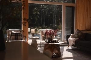 Saint-Rémi-dʼAmherstStarry Tremblant l Design Glass View Cabin Spa Lake的客厅配有桌椅和大窗户