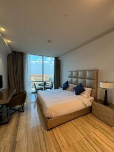 利雅德4Leisure Suites DAMAC Esclusiva Towers的配有一张床、一张桌子和一张桌子的酒店客房