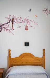 巴萨HOSTAL CACHE的一间卧室,床上有一棵树,上面有鸟儿