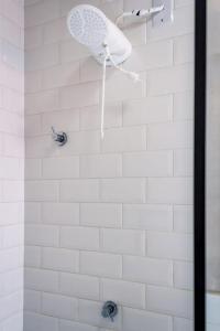 韦尔卡鲍Aconchegante Chale com Wi-Fi no Vale do Capao-BA的白色瓷砖淋浴和淋浴头