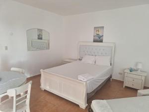 Juan PedroApartamento frente al mar Juan dolio的白色的卧室配有白色的床和一张桌子