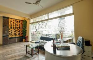 班加罗尔Falcon Suites Koramangala的客厅设有桌子和大窗户