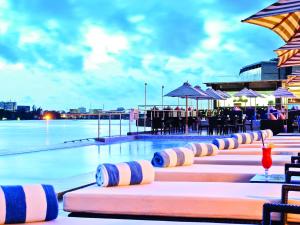 拉各斯安克雷奇丽笙酒店的一个带桌椅和遮阳伞的游泳池